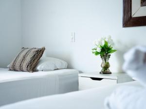 a white room with a vase of flowers on a table at Hotel Koray in San Andrés