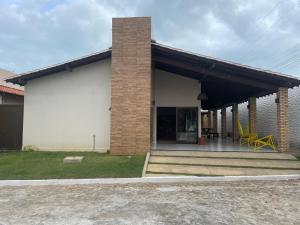 路易斯科雷亚Casa20的砖屋,带黄色椅子的门廊