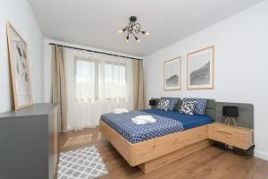 a bedroom with a blue bed and a window at The 75 in Târgu-Mureş