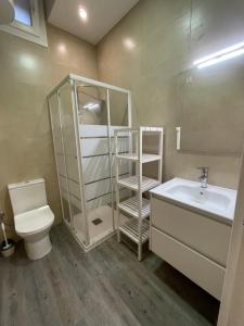 y baño con aseo, lavabo y espejo. en Apartamento Forn Vell en Sant Feliu de Guixols