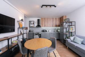 a kitchen and living room with a table and a couch at The 75 in Târgu-Mureş
