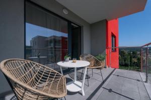 a patio with a table and chairs on a balcony at The 75 in Târgu-Mureş