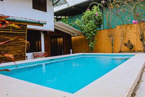 a swimming pool in front of a house at Casa Sua--Cozy 3 Bedroom Dominical Beach Cottage with Pool in Dominical