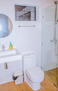 y baño blanco con aseo y ducha. en Casa Sua--Cozy 3 Bedroom Dominical Beach Cottage with Pool en Dominical