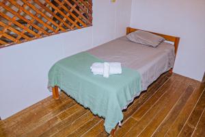 a bedroom with a bed with a towel on a table at Casa Sua--Cozy 3 Bedroom Dominical Beach Cottage with Pool in Dominical