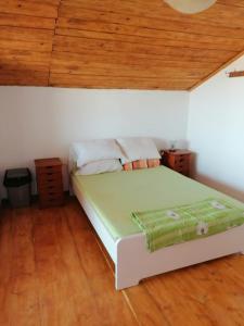 a white bed in a room with a wooden ceiling at Briza Marii in Costinesti