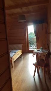 a room with a bed and a table and a window at Dworek na Klinie in Kościelisko