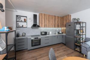 a kitchen with stainless steel appliances and wooden cabinets at The 75 in Târgu-Mureş