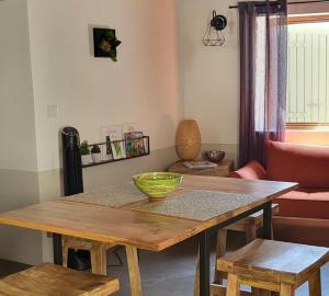 a dining room table with a green bowl on top of it at PROCHE UZES LE COCON DU PEINTRE ANGLAIS in Sanilhac-et-Sagriès