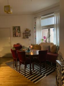 sala de estar con mesa, sillas y sofá en Rum med eget badrum och stort, delat kök,centralt i Malmö, en Malmö