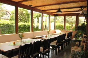 - une salle à manger avec des tables, des chaises et des fenêtres dans l'établissement Die Radler-Scheune Finsterbergen, à Friedrichroda