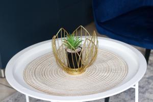 a small plant in a gold vase on a white table at Deluxe Guest Suite at Warner Beach in Kingsburgh