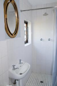 a white bathroom with a sink and a mirror at Deluxe Guest Suite at Warner Beach in Kingsburgh