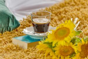 阿拉德Dodi Studio Compact的坐在鲜花旁的书上喝杯咖啡