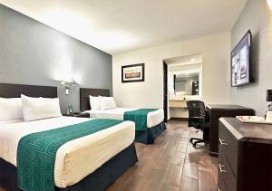 シウダード・オブレゴンにあるInHouse Obregónのベッド2台とデスクが備わるホテルルームです。