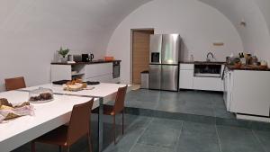 a kitchen with white tables and stainless steel appliances at Les chambres du Chateau de Fenestrelle in Aubagne