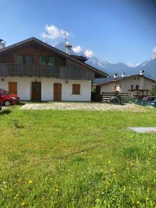 una casa con un campo verde delante de ella en Mountain Home, en Valle di Cadore