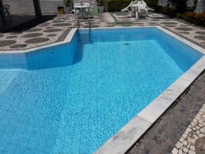Una piscina con agua azul en un patio. en Apto Stiep Inteiro, en Salvador