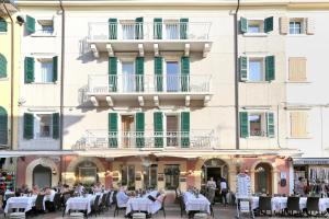 a group of people sitting at tables in front of a building at Ancora Suites in Bardolino