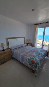 a bedroom with a bed and a view of the ocean at Mediterranean Lookout from Vinaròs in Vinarós