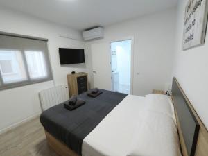 a bedroom with a bed with two slippers on it at Apartamento New Tarraco in Tarragona