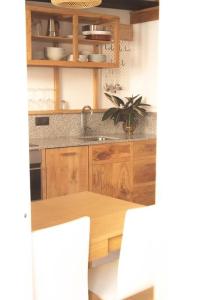 eine Küche mit Holzschränken und einem Holztisch in der Unterkunft Ferreiros - Wood Design apartments in Puentedeume