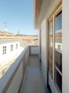 einen Balkon in einem weißen Gebäude mit Fenster in der Unterkunft Ferreiros - Wood Design apartments in Puentedeume