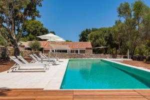 a swimming pool with chairs and a house at Alcotx Country Club in Es Mercadal