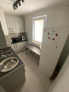 a kitchen with a refrigerator and a sink at Apartament na Broniewskiego in Gdańsk