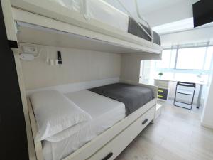 ein Schlafzimmer mit einem Etagenbett in einem kleinen Zimmer in der Unterkunft Apartamento New Tarraco in Tarragona