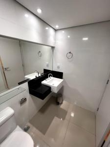 bagno con lavandino, servizi igienici e specchio di SG Apart Hotel a São Gonçalo do Rio Abaixo