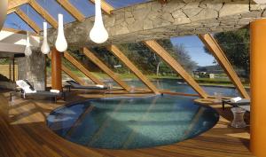 - une grande piscine dans une maison dotée d'un plafond dans l'établissement Rochester Bariloche Suites & Spa, à San Carlos de Bariloche