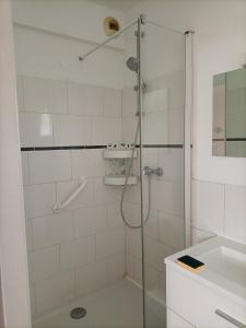 una ducha con una puerta de cristal junto a un lavabo en La Jolie Dourbie de Nant en Nant