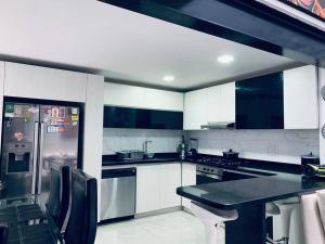 a kitchen with white cabinets and a black counter top at Espectacular Casa De Lujo in Manizales