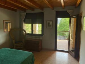 1 dormitorio con 1 cama y puerta corredera de cristal en Ca la Sophie a 8km Andorra, en Anserall
