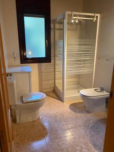 a bathroom with a toilet and a glass shower at Ca la Sophie a 8km Andorra in Anserall