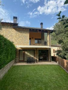 a house with a patio with a table and chairs at Ca la Sophie a 8km Andorra in Anserall