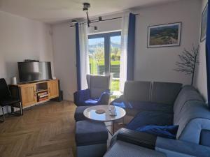 salon z kanapą, stołem i telewizorem w obiekcie Apartament rodzinny Słoneczna Sosnówka w mieście Sosnówka