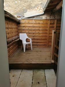 a white chair sitting on a wooden patio at Studio Climatisé 38m2 Poitiers proche Futuroscope in Buxerolles