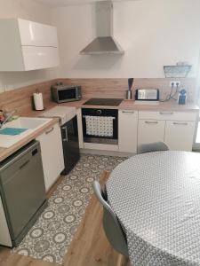 a kitchen with a table and a stove and a table and chairs at Studio Climatisé 38m2 Poitiers proche Futuroscope in Buxerolles