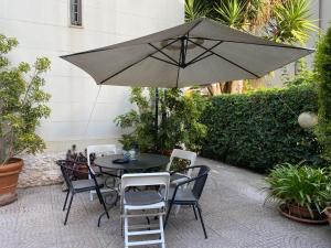 un tavolo e sedie con ombrellone su un patio di Villa Luigi XVI a Taranto
