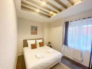 La suite Carthagène des Indes - centre ville , spa & terrasse privée في بيتون: غرفة نوم بسرير وملاءات بيضاء ونافذة