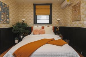 a bedroom with a large bed with an orange blanket on it at The Cat's Meow Apt 1 Sunset Heights in El Paso