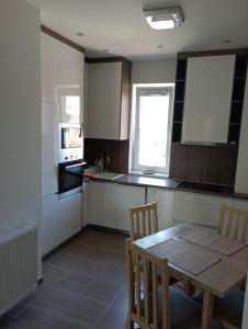 een keuken met een houten tafel en een tafel met stoelen bij Thaly 5/1 in Debrecen