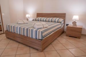 a bedroom with a bed with striped sheets and two lamps at Casa Della Nonna in Manfredonia