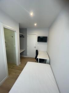 a room with a bed and a table and a desk at Habitaciones Arrisal in Bilbao +15 photos
