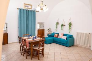 a living room with a table and a blue couch at Casa Della Nonna in Manfredonia