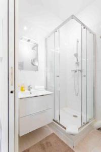 ein weißes Bad mit einer Dusche und einem Waschbecken in der Unterkunft MARSEILLE T2 Central et lumineux in Marseille