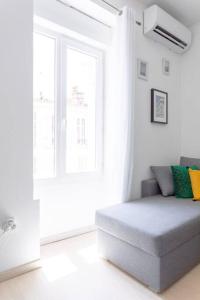 ein weißes Zimmer mit einem Sofa vor dem Fenster in der Unterkunft MARSEILLE T2 Central et lumineux in Marseille