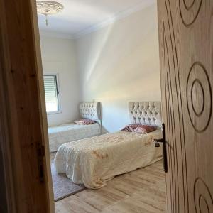 a bedroom with a bed and a chair at Ajloun Rest House in ‘Ayn Jannā